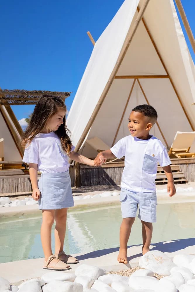 Calamaro · dos niños de la mano junto a la piscina, campaña de la marca